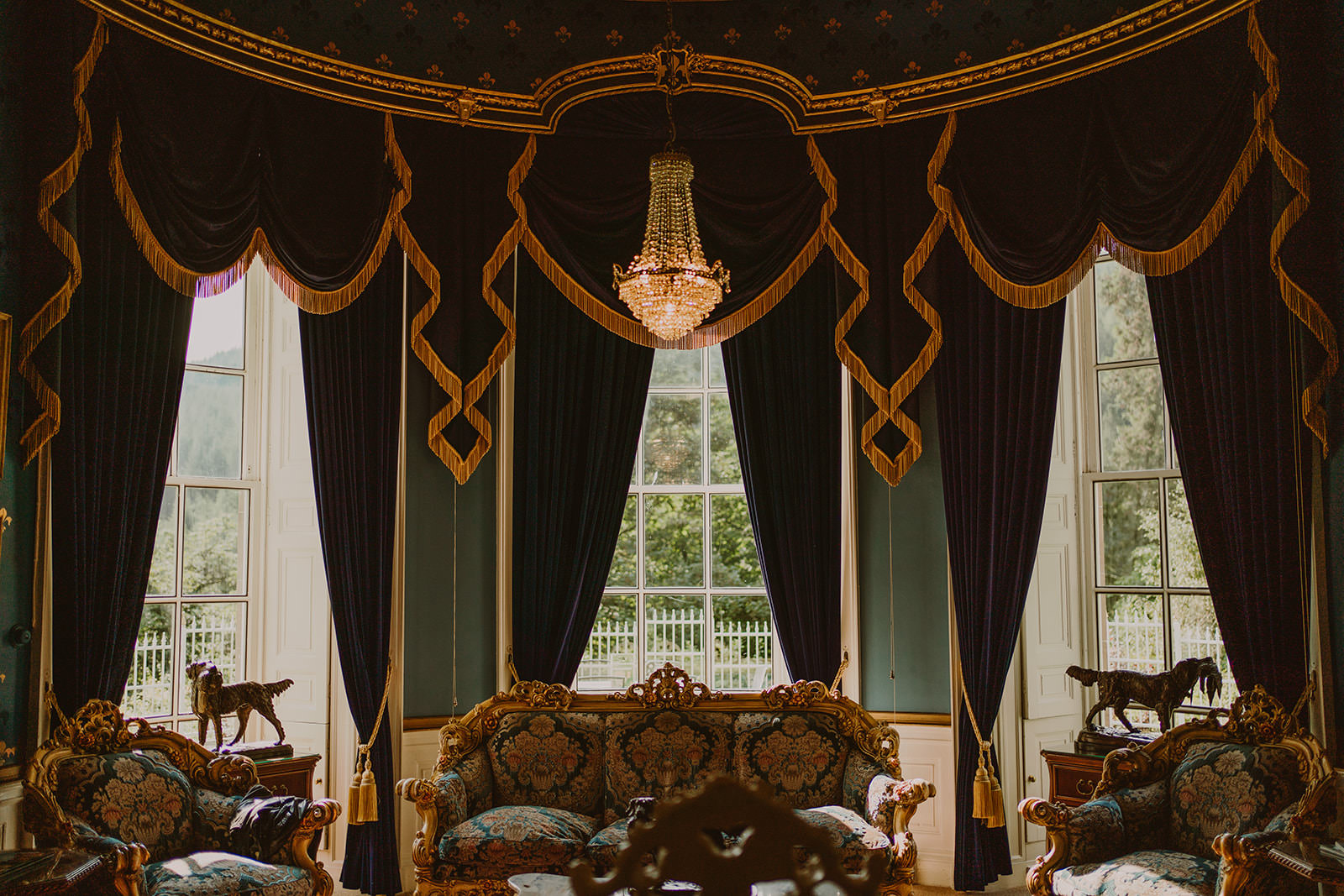 Historic reception room at Drumtochty Castle with tall windows and dark drapes