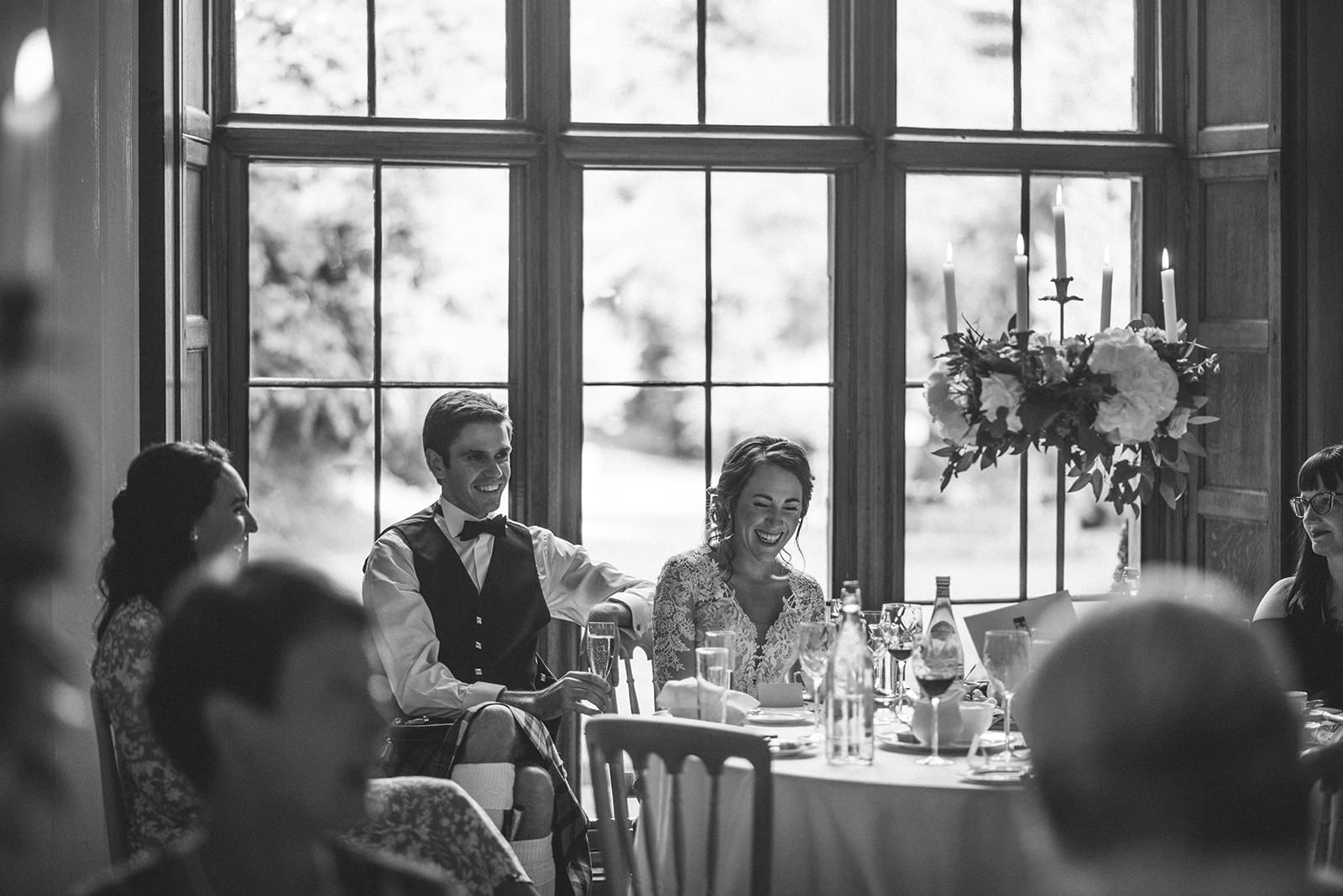 Black and white photograph of the newlyweds seated together during their wedding reception