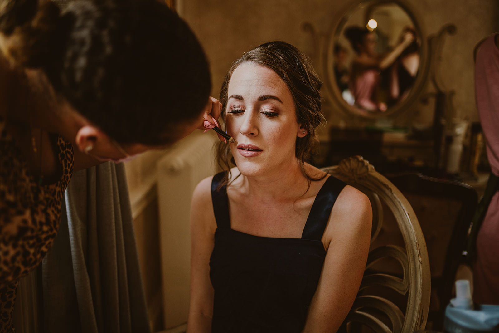 Bride having her makeup applied while getting ready at Drumtochty Castle