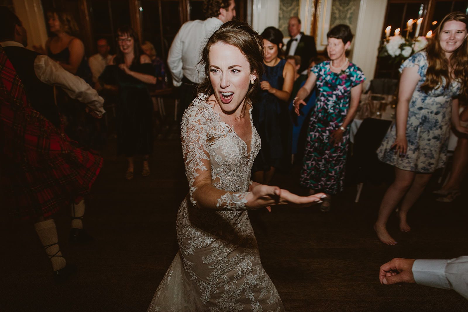 Bride smiling and celebrating with friends on the wedding dance floor